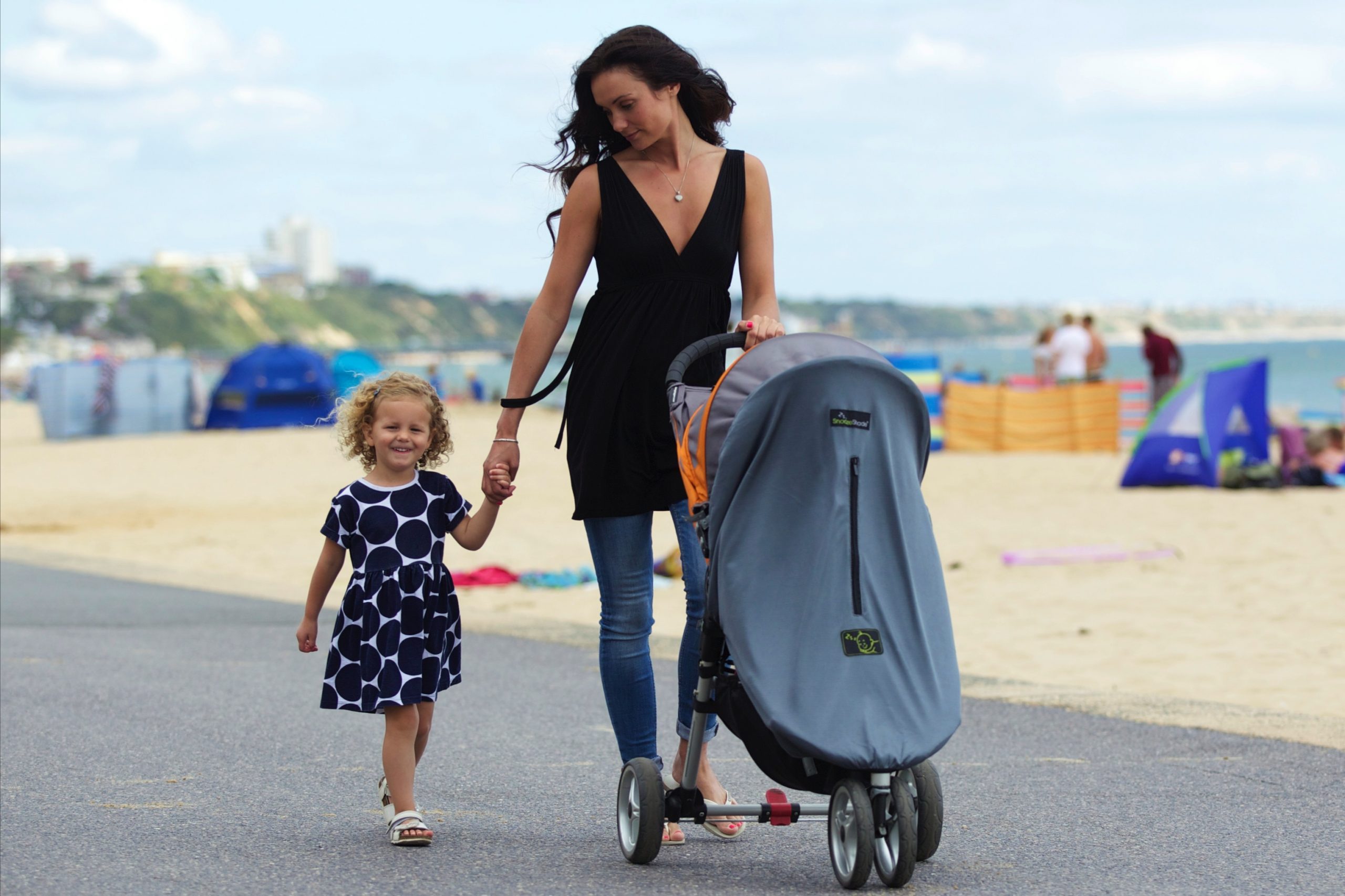mother walking with daughter next to beach